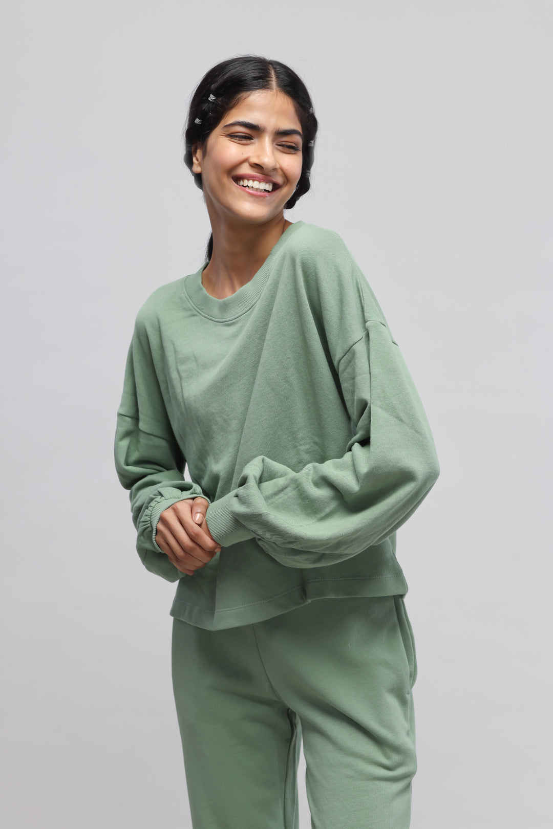 Mint green puffed sleeves terry sweatshirt worn with a joyful expression.