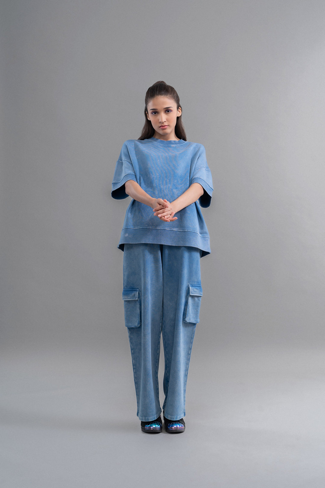 Denim wash 100% cotton terry cargo pant model in blue outfit.