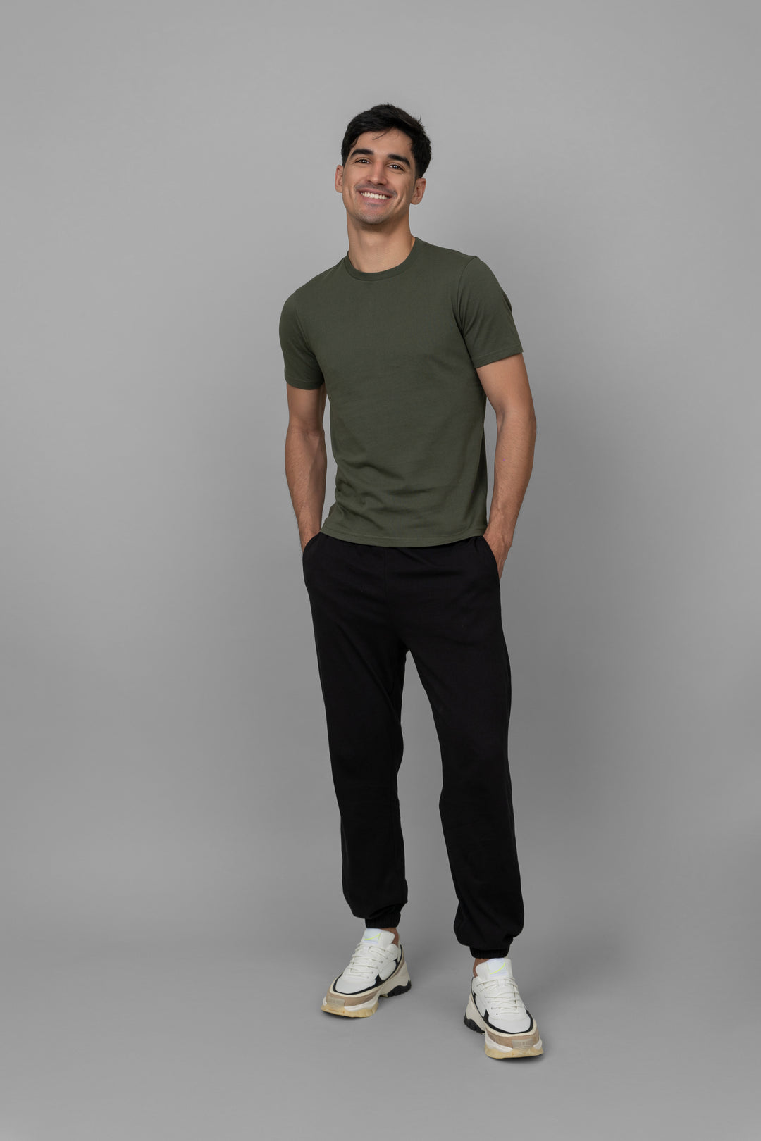 Black men's joggers styled with a casual olive t-shirt and sneakers.