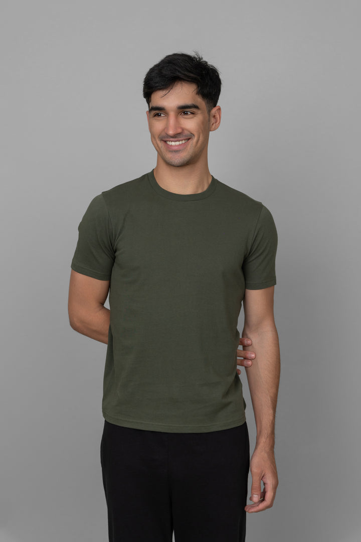 Green men's jogger set model smiling casually in stylish athletic wear.