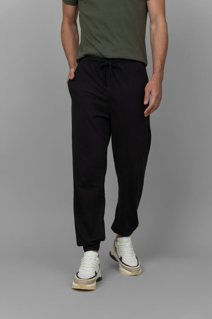 Black men's joggers styled with a casual green shirt.