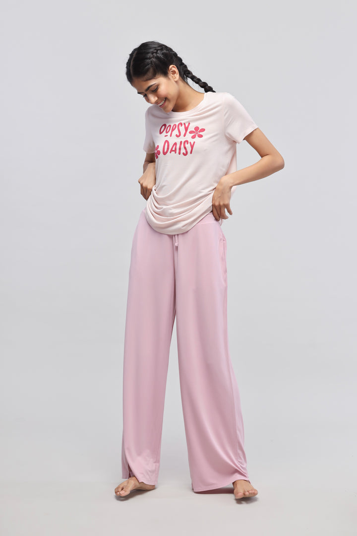 Oopsy Daisy flared pajama set model smiling in pink loungewear.