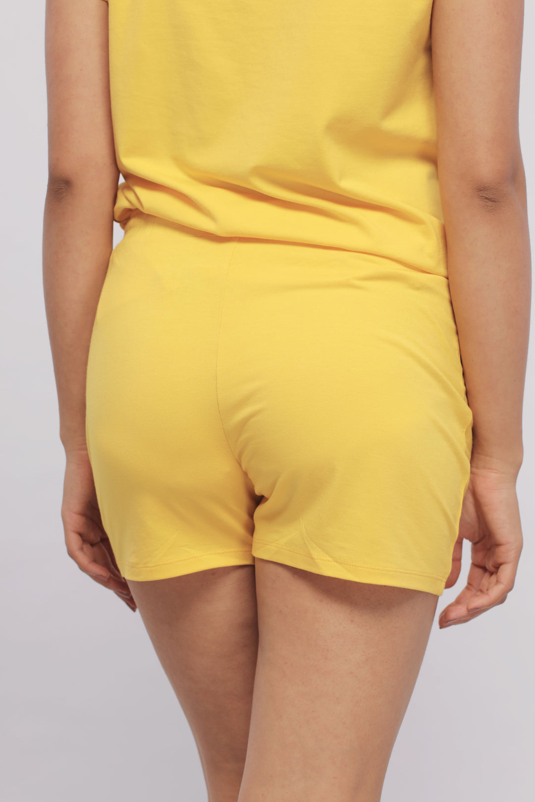 Sunny Lime Supima® shorts on model in yellow outfit.