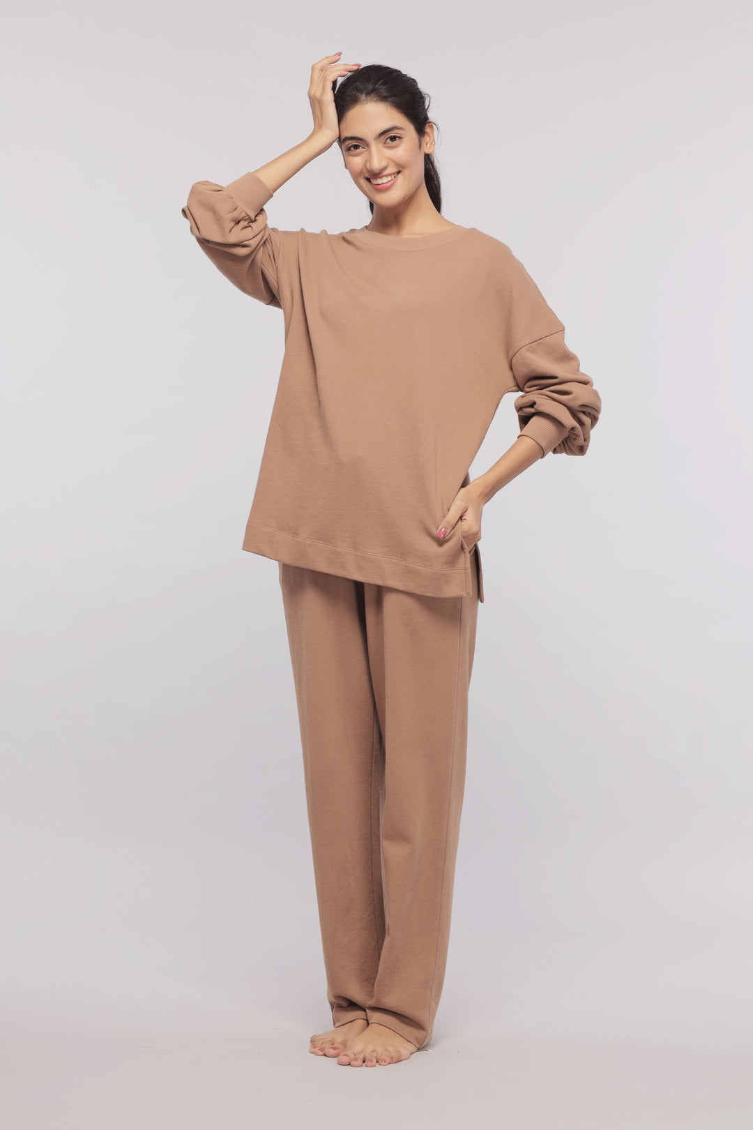 Brown terry long sweatshirt styled with matching pants, woman posing.