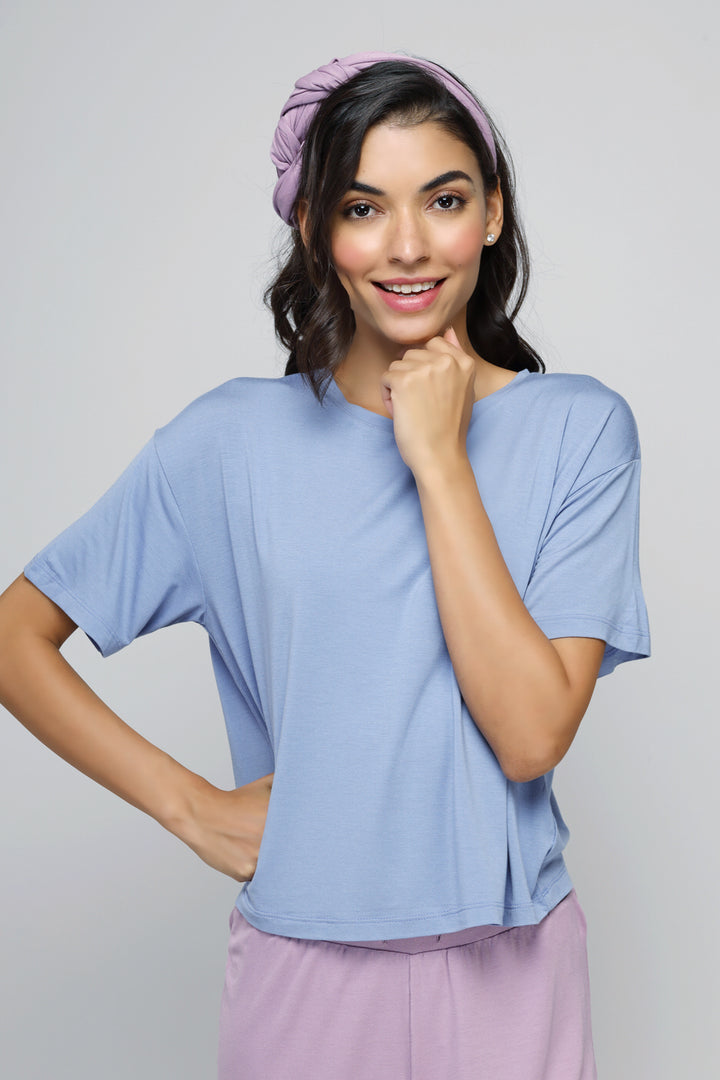 Smiling woman wearing a calming blue crop top and headband.