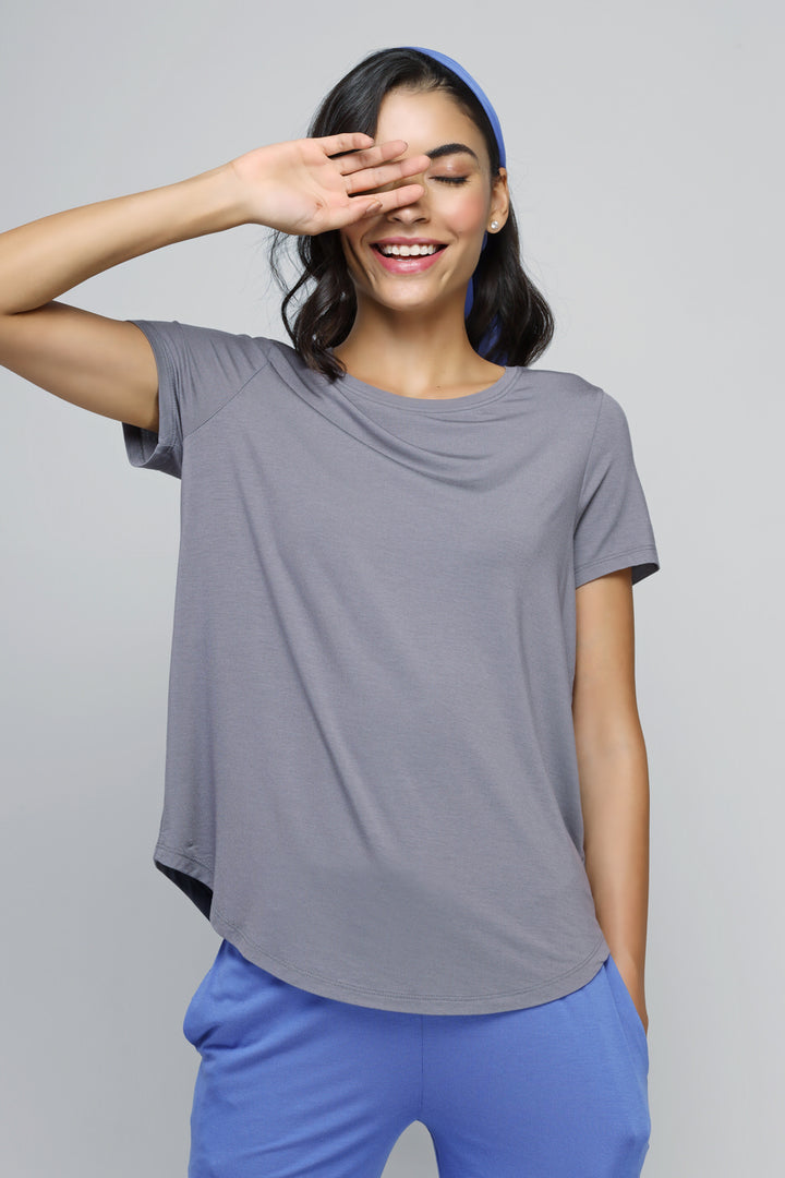 Smiling woman in relaxed blue flared lounge set posing stylishly.