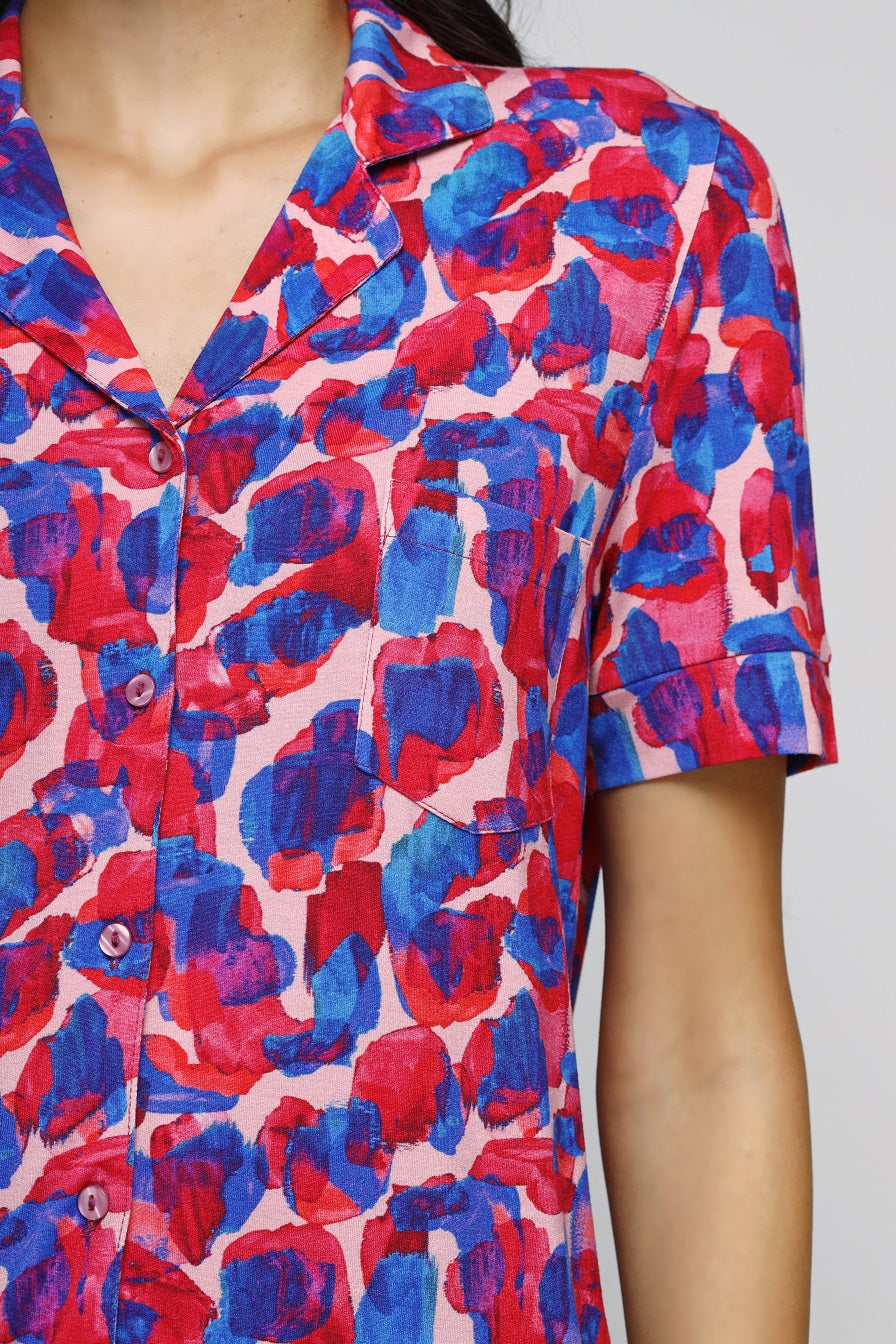 Artsy watercolor button-down pajama set in vibrant red and blue patterns.