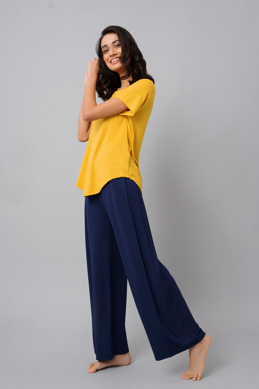 Buttercup yellow top worn with navy blue pants, smiling model.