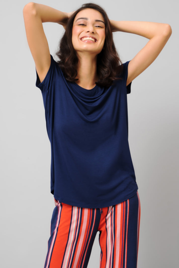 Smiling woman in Classic Stripe Capri Set, navy top with striped pants.