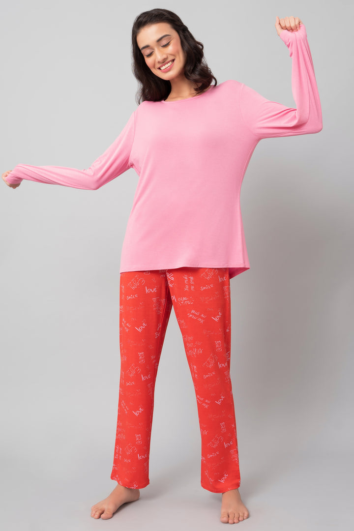 Joyful model wearing Love Escape Pajama Set in pink and red.