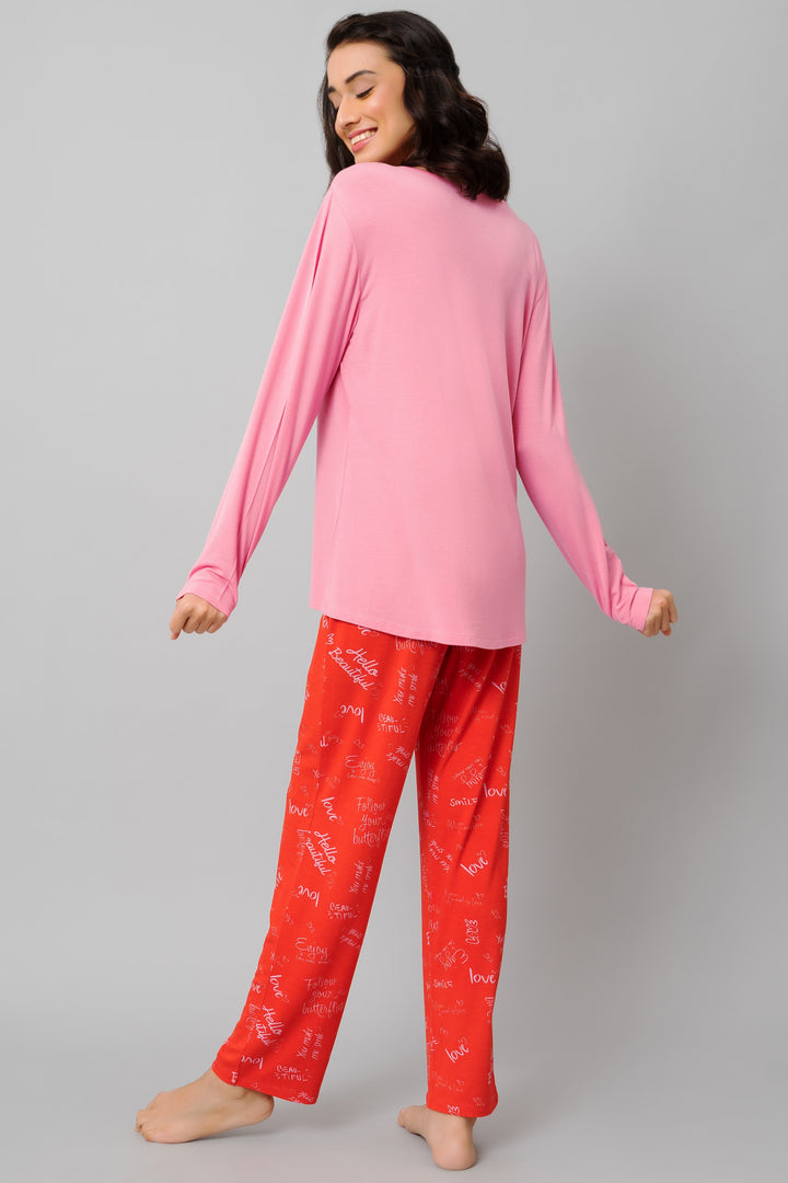 Model wearing Love Escape Pajama Set with pink top and red patterned pants.