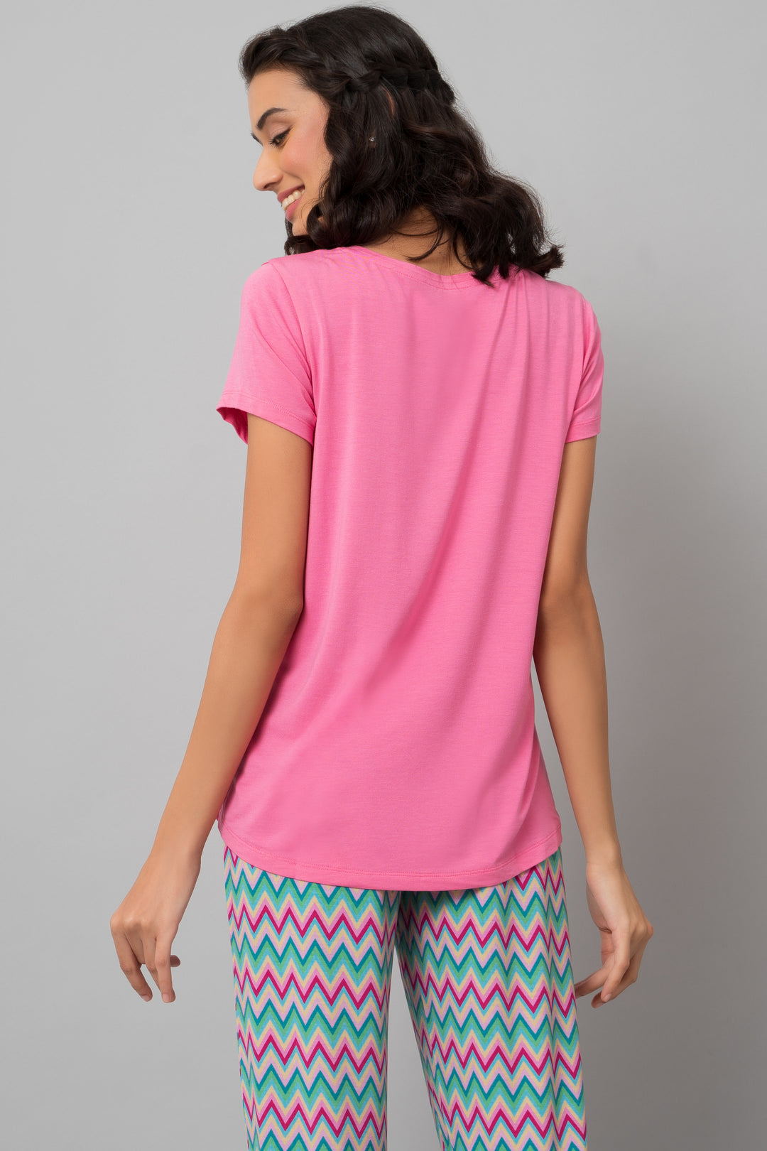 Mellow Pink Top displayed on a model, showcasing back view and patterned pants.