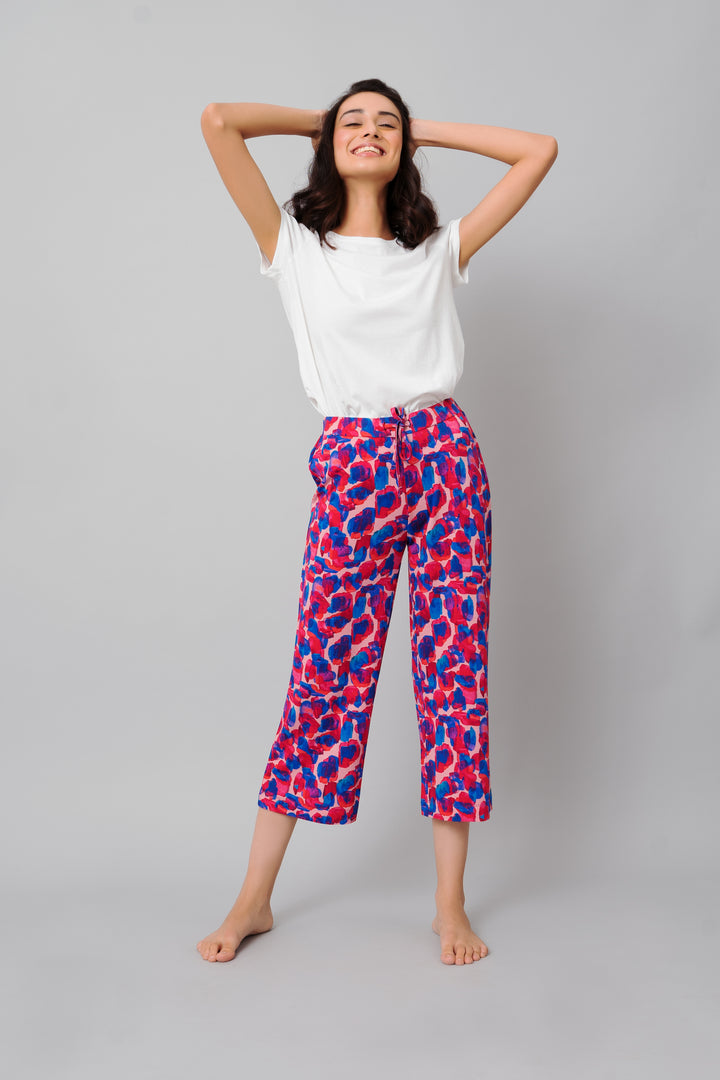 Model wearing Artsy Watercolor Capri pants with vibrant floral pattern.