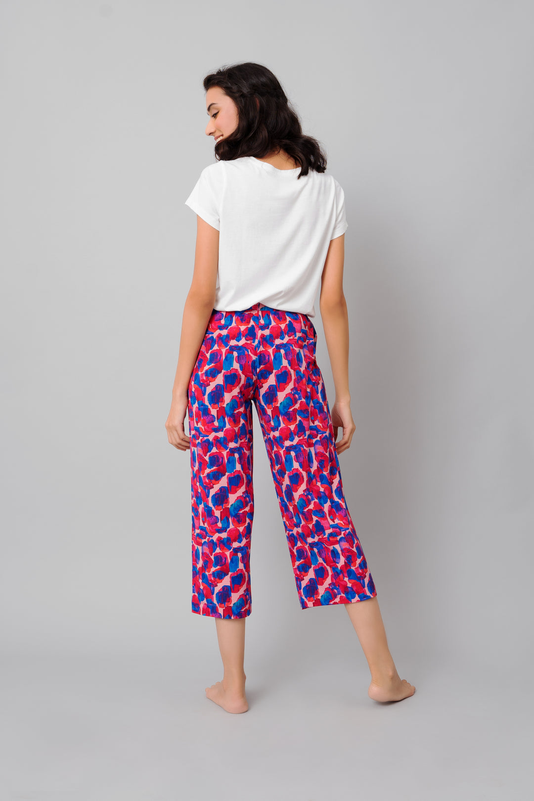 Woman wearing Artsy Watercolor Capri pants with colorful print.