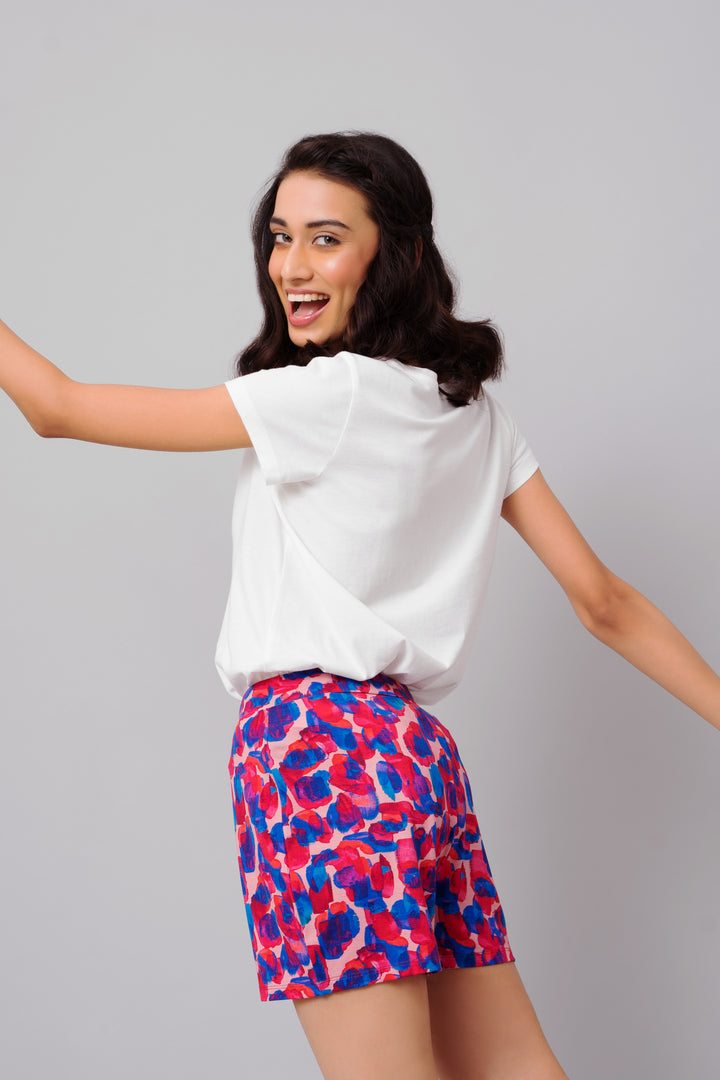 Model showcasing colorful Artsy Watercolor Shorts in casual outfit.