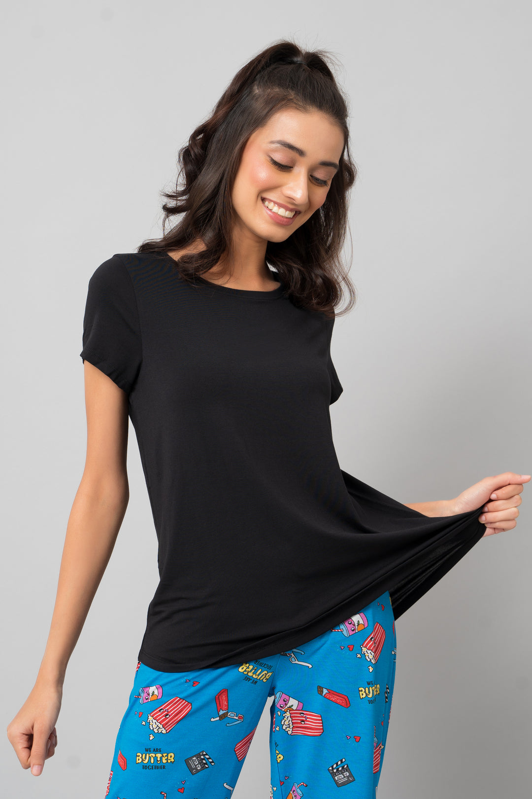 Model wearing Everyday Black Capri Set with playful blue pajama bottoms.