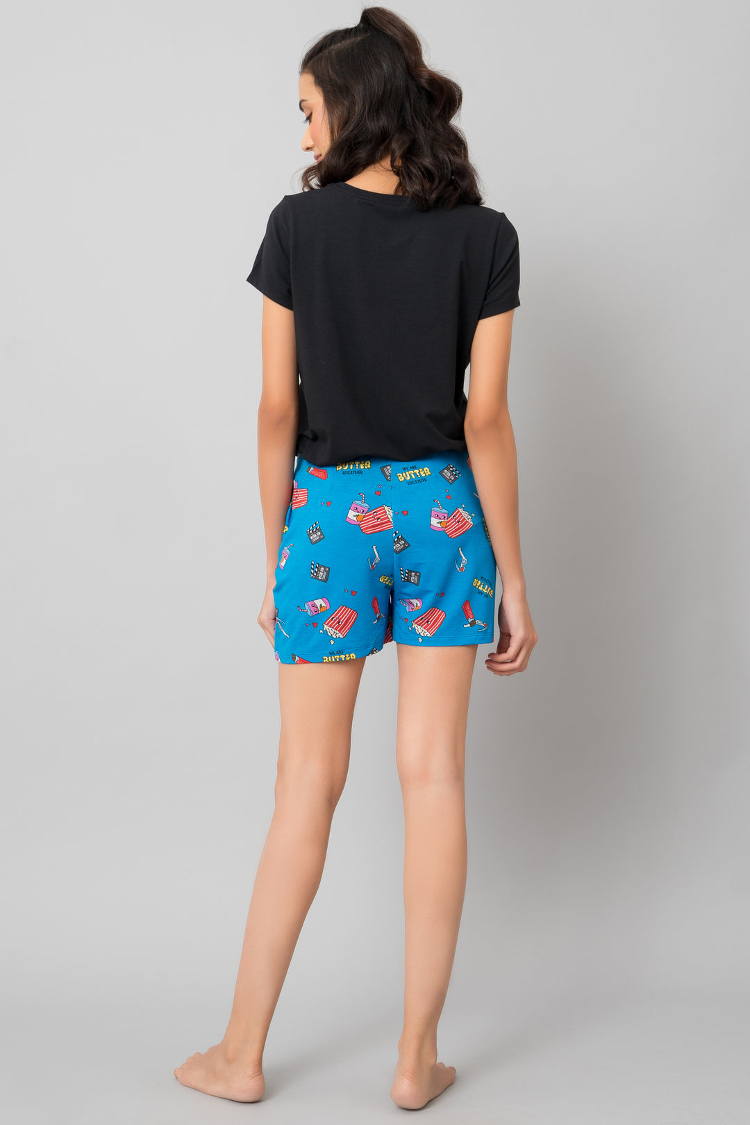 "Model wearing Butter Together Shorts with playful blue pattern."