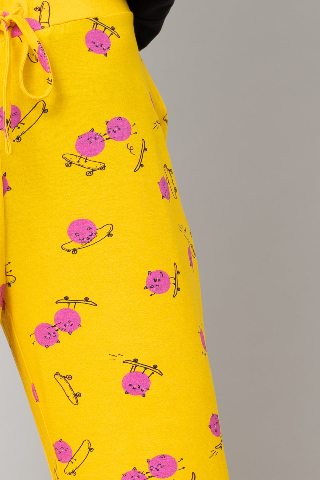 Cute yellow pajama pants with playful kitty and skateboard print.