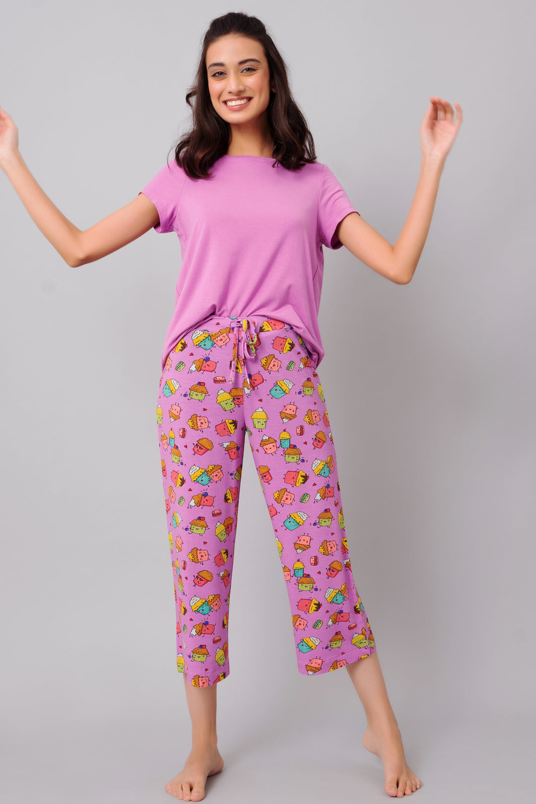 Smiling model wearing pink Stud Muffin Capri and top with playful prints.