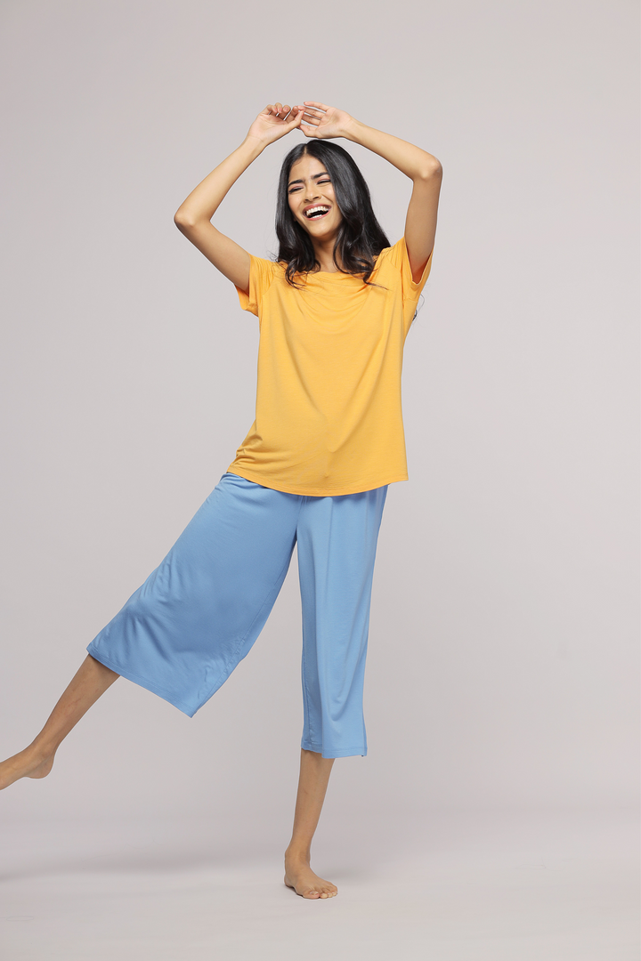 Smiling model wearing Horizon Blue Culotte Set, yellow top and blue culottes.