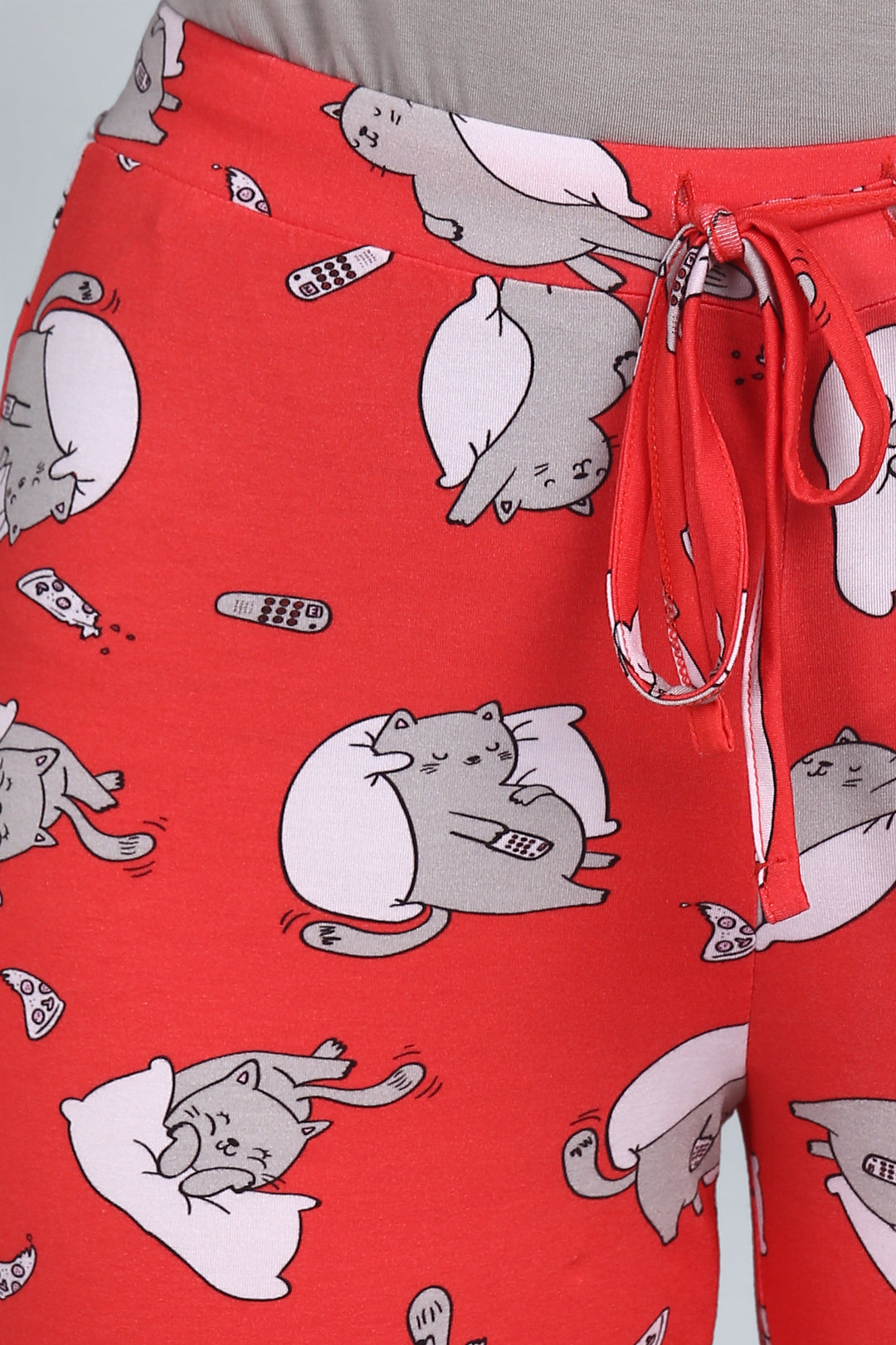 Red cat-print capri pants with remote and pillow design.