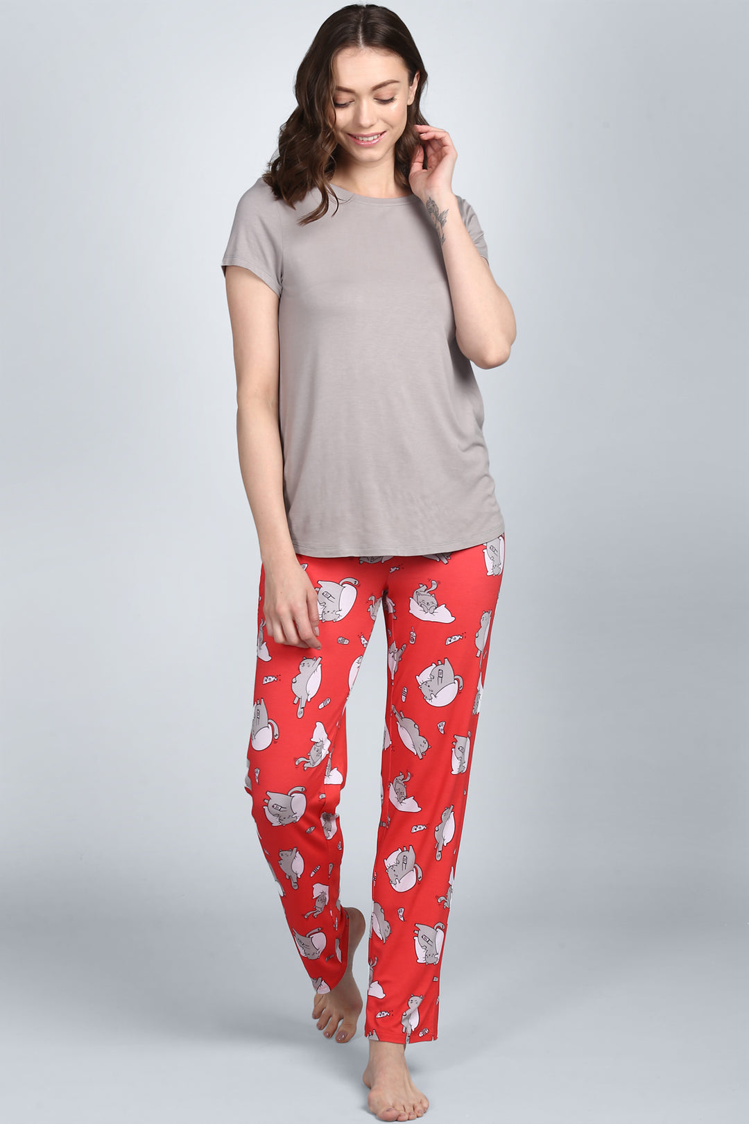 Woman smiling in Lazy Cat Pajamas with playful cat design.