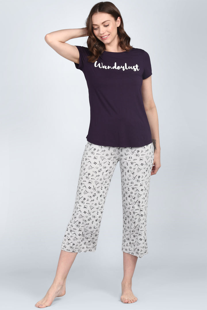 Stylish women's pajama set featuring "Wanderlust" theme and travel icons.