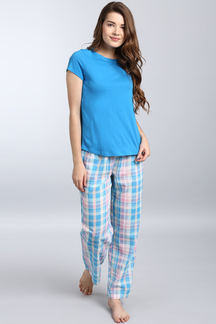 Woman wearing a soothing blue top with plaid pants.