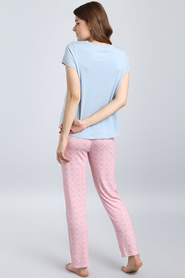 Model wearing a powder blue top with pink pants.