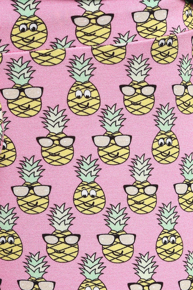 Colorful pineapple pattern on pink fabric for tropical shorts set.