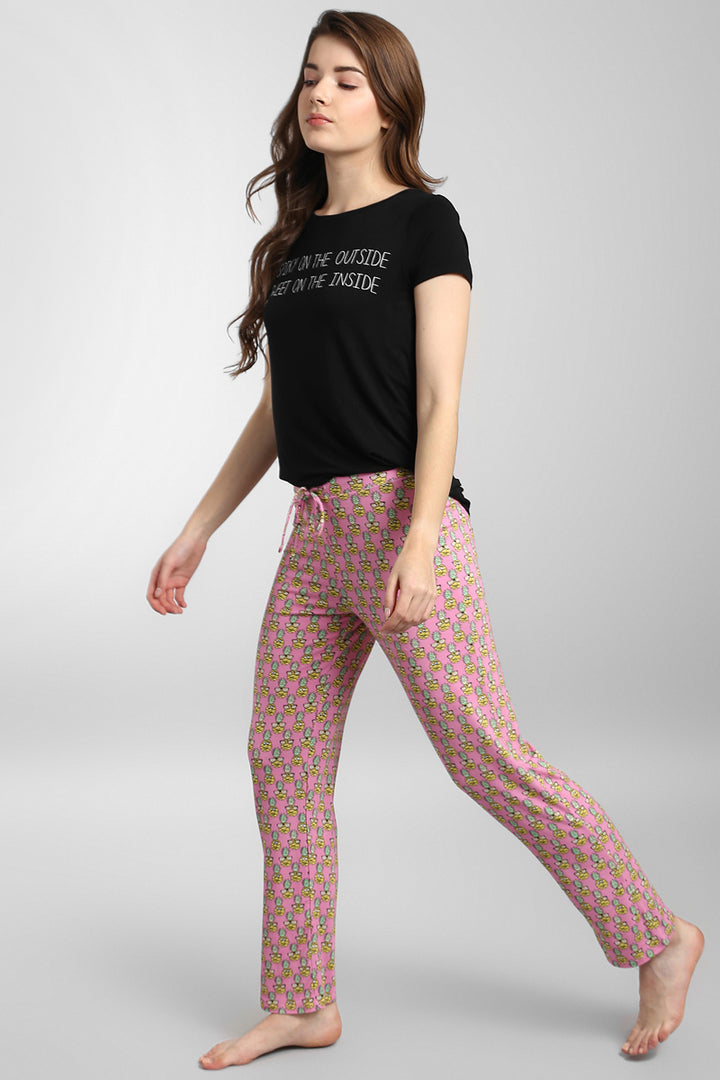 Model wearing Tropical Vacay Pajama Set with playful pink pants and black tee.