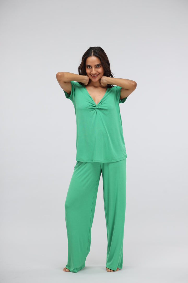 Green bee flared modal lounge set with knot top, model posing smiling.