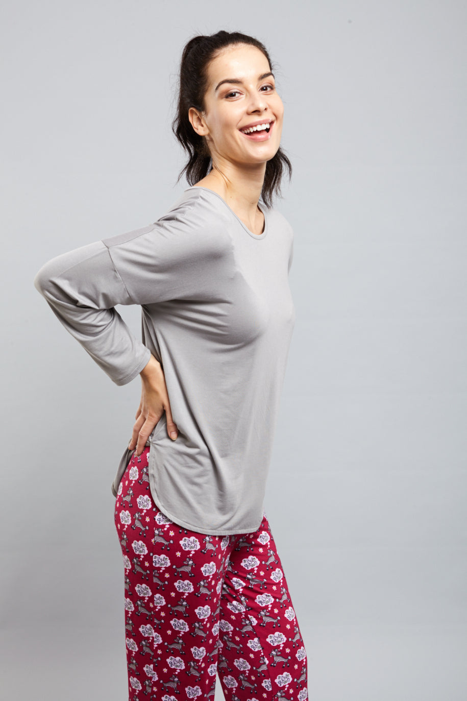 Smiling woman wearing a Dreamy Grey Top with stylish loungewear.