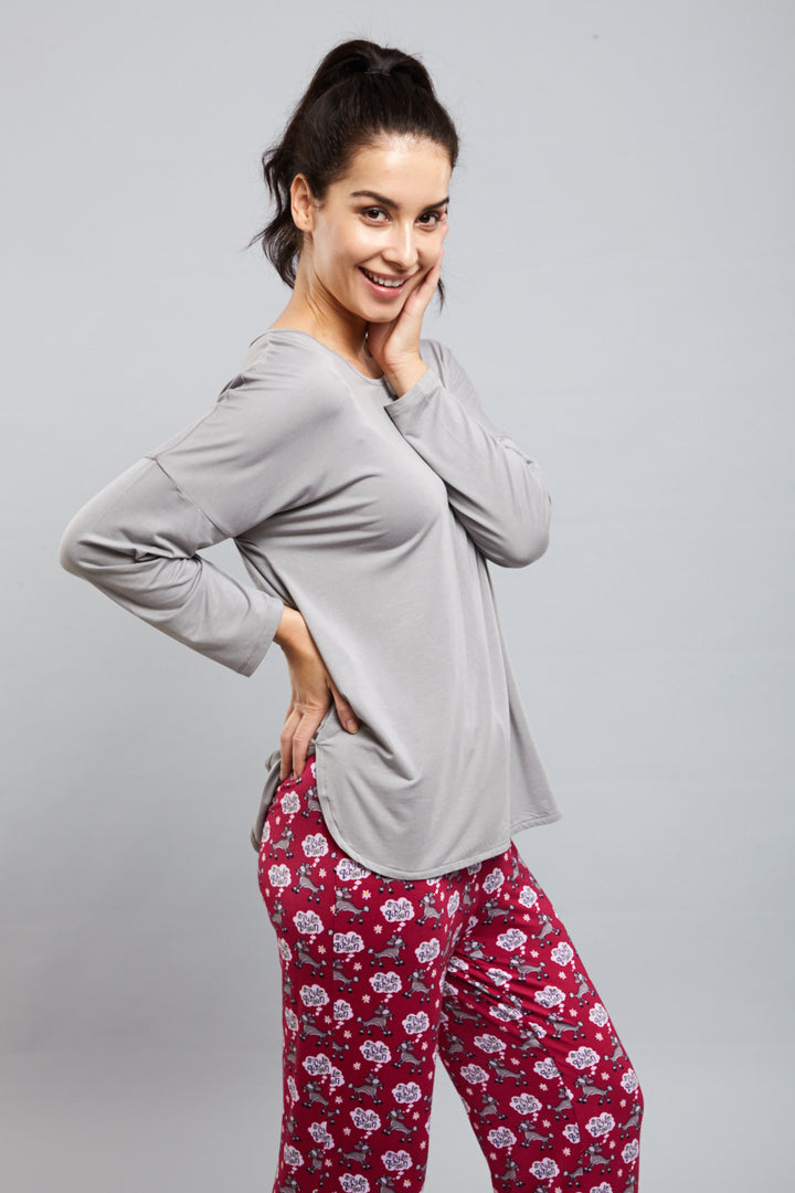 Woman wearing Dreamy Grey Top with patterned pants, smiling confidently.