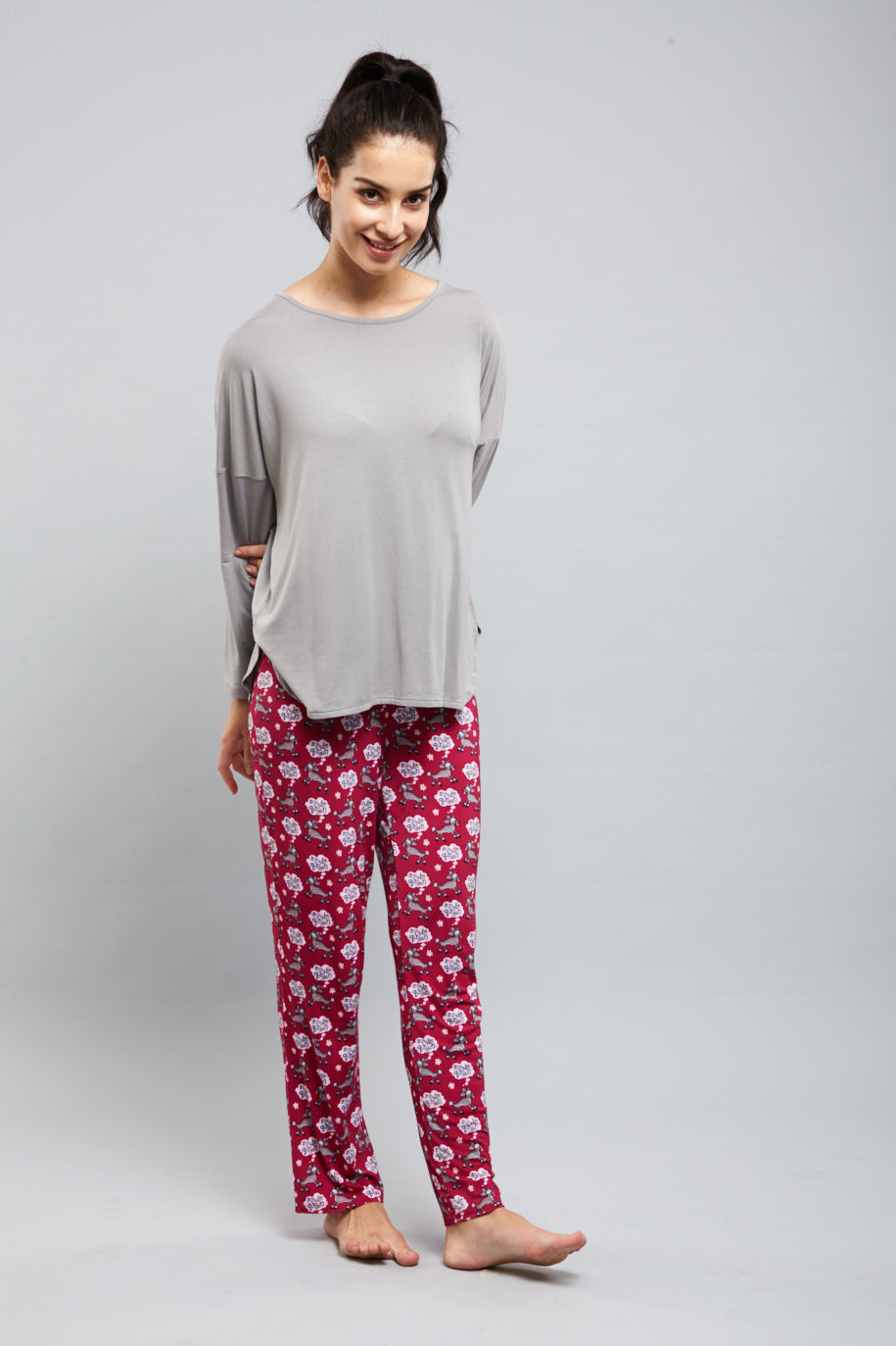 Stylish woman modeling Style Queen Pajamas in red floral design.