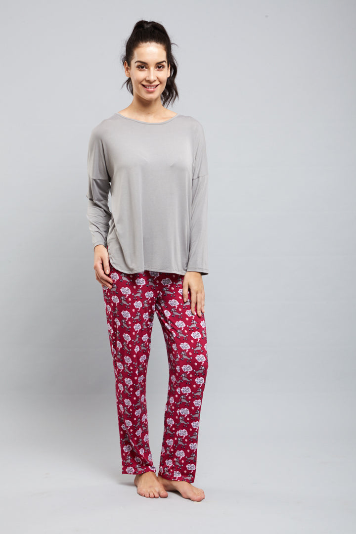 Stylish woman wearing Style Queen Pajamas in comfortable gray and floral print.