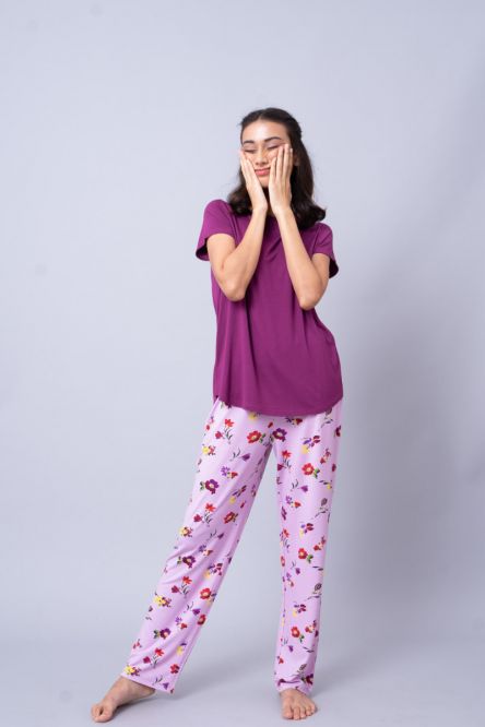 Cozy woman modeling Winter Romance Pajama Set with floral pants.