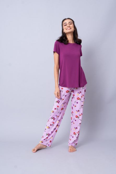 Woman wearing Winter Romance Pajamas with floral print and purple top.