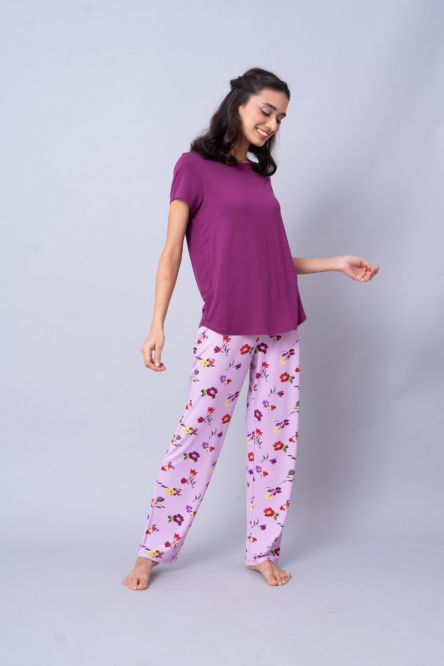 Model wearing Winter Romance Pajamas, purple top and floral pants.